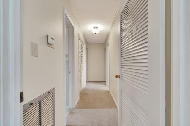 corridor featuring crown molding and light carpet