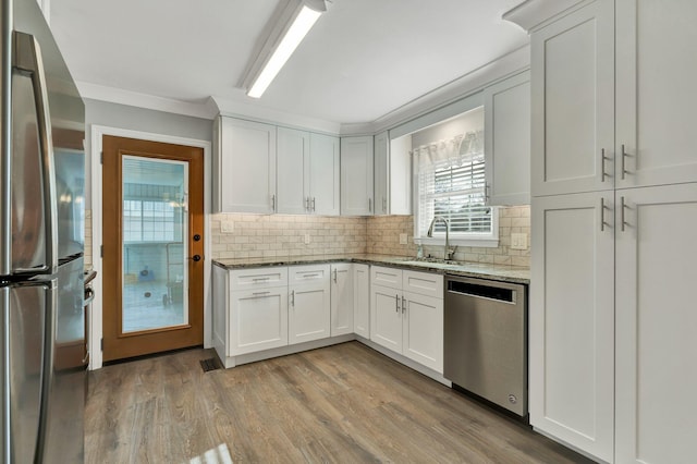 kitchen featuring dark stone countertops, sink, white cabinets, and stainless steel appliances