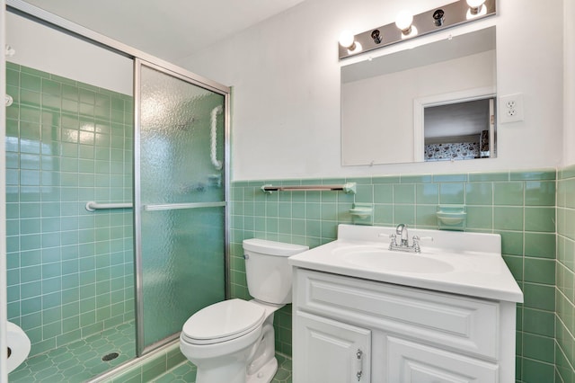 bathroom with tile patterned flooring, vanity, a shower with door, and tile walls