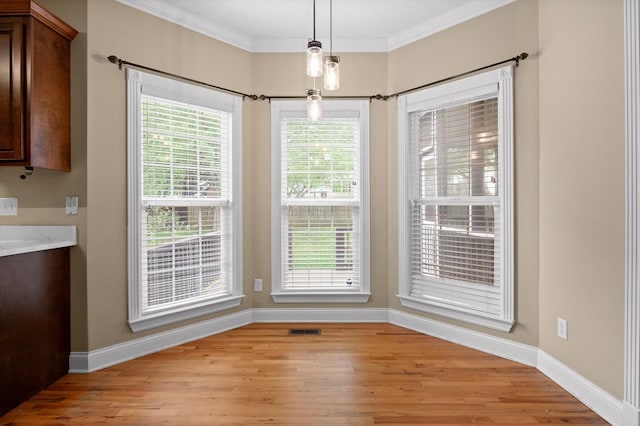unfurnished dining area featuring baseboards, light wood finished floors, and a wealth of natural light
