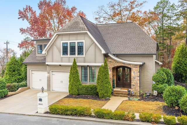 english style home featuring french doors and a garage