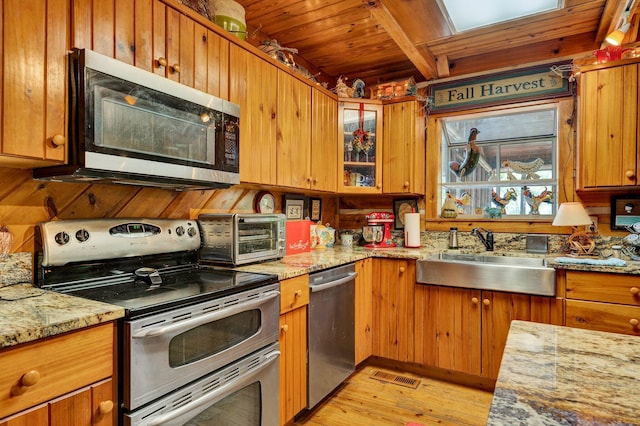 362 River Run Rd, Calhoun, TN 37309 - kitchen featuring stainless steel appliances, a sink, light wood-style floors, light stone counters, and brown cabinetry
