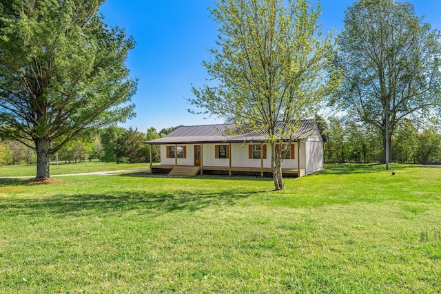 exterior space featuring covered porch, a front yard, and metal roof