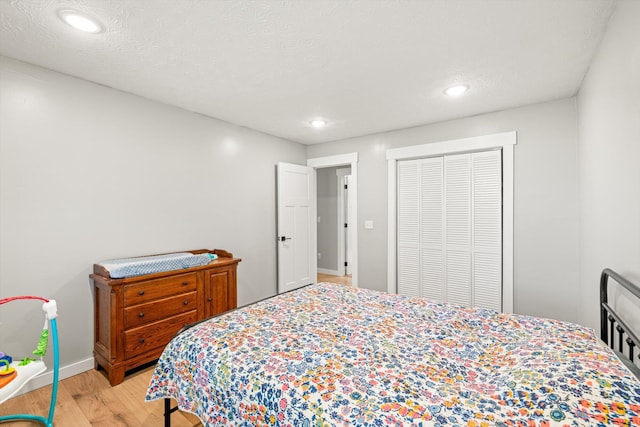 bedroom with baseboards, a closet, light wood finished floors, and recessed lighting