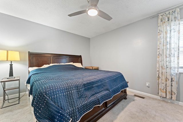 carpeted bedroom featuring a textured ceiling and ceiling fan