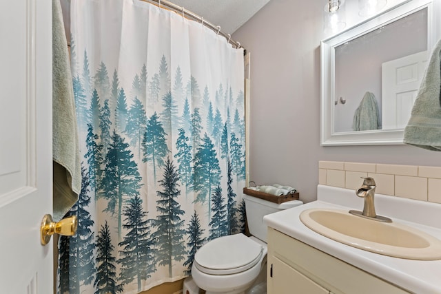 bathroom featuring vanity, a textured ceiling, and toilet