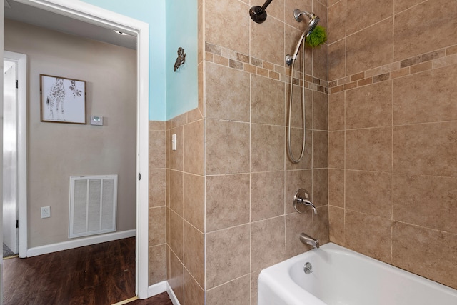 bathroom with tiled shower / bath and hardwood / wood-style flooring