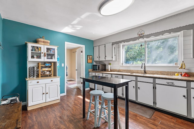 kitchen with sink, white cabinets, and dark wood-type flooring