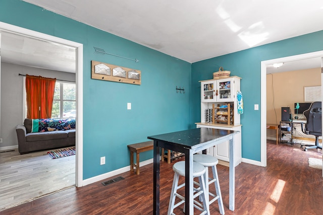 dining area with dark hardwood / wood-style flooring