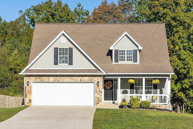 view of front of home featuring a porch, a garage, and a front yard