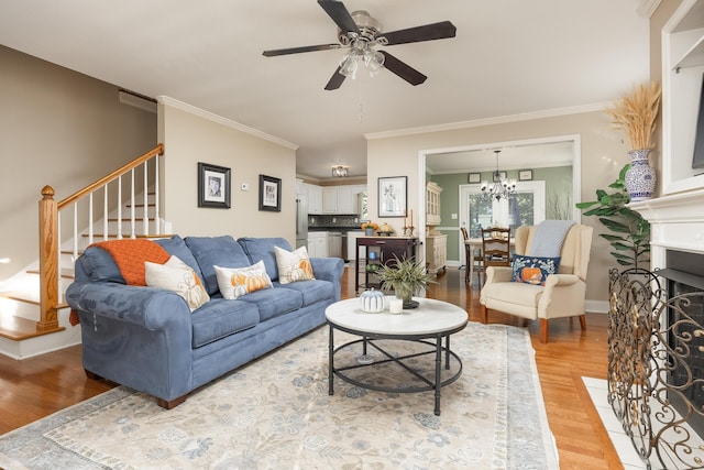 living room with crown molding, ceiling fan with notable chandelier, and hardwood / wood-style flooring