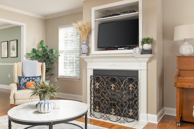 living area featuring crown molding and hardwood / wood-style flooring