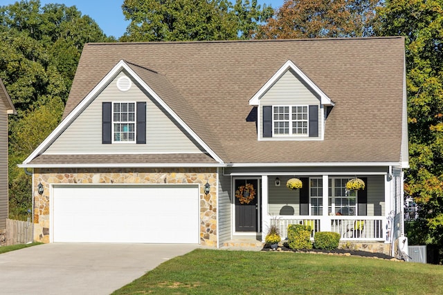 view of front of house featuring a front yard, a porch, and a garage