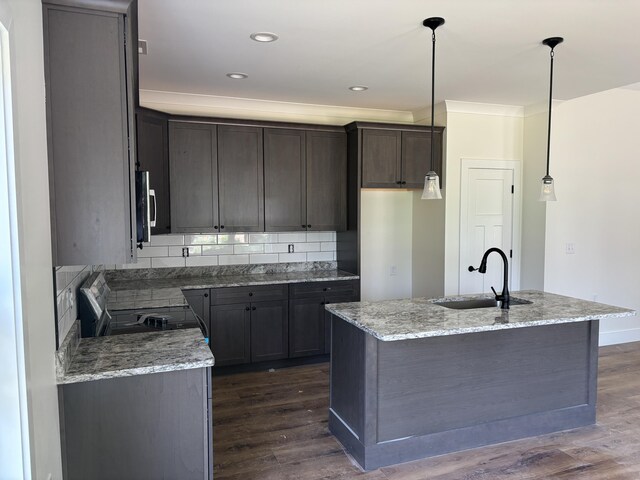 2901 Bobo Ave NW, Cleveland, TN 37312 - kitchen with electric stove, dark wood-type flooring, stainless steel microwave, light stone counters, and an island with sink