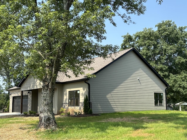 2901 Bobo Ave NW, Cleveland, TN 37312 - view of property exterior with an attached garage, a lawn, driveway, stone siding, and roof with shingles
