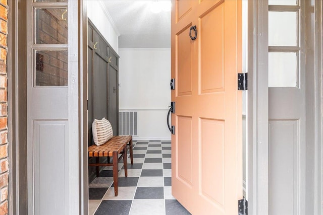 mudroom with a textured ceiling and crown molding