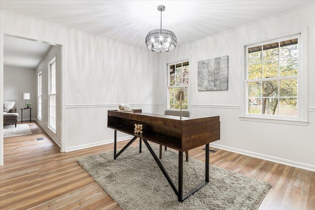 office with hardwood / wood-style floors and a chandelier