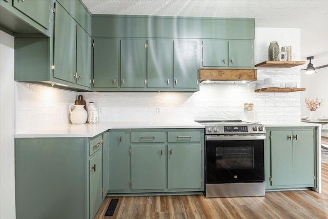 kitchen featuring hardwood / wood-style floors, exhaust hood, green cabinetry, electric range, and a textured ceiling