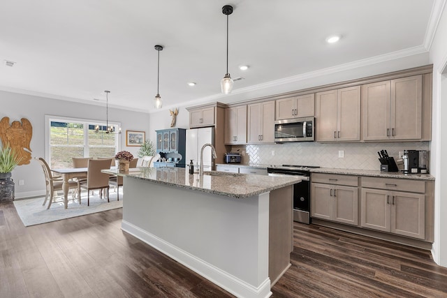 kitchen with light stone counters, dark hardwood / wood-style flooring, stainless steel appliances, and hanging light fixtures