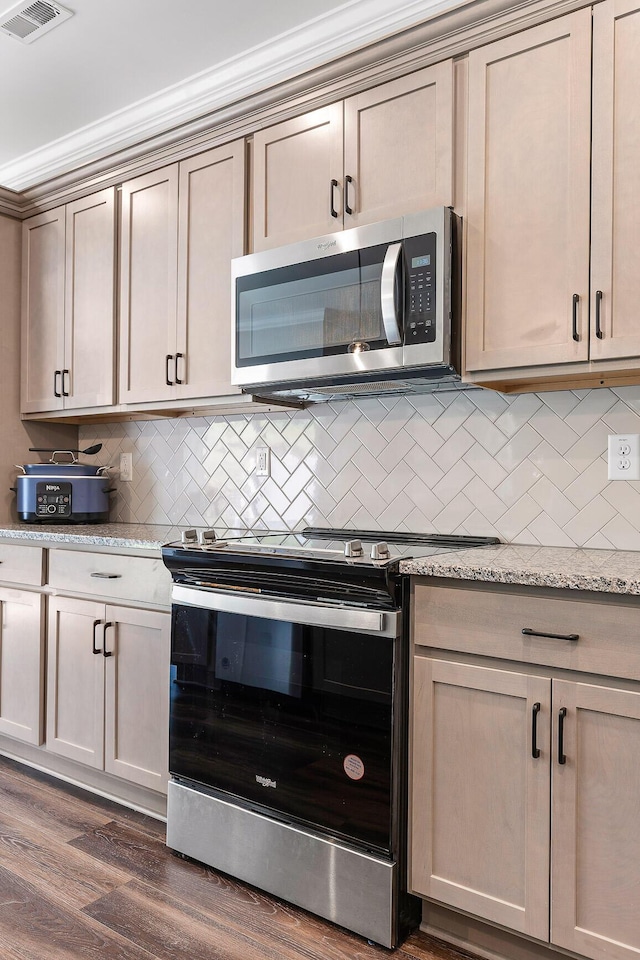 kitchen featuring light stone countertops, appliances with stainless steel finishes, tasteful backsplash, ornamental molding, and dark hardwood / wood-style floors