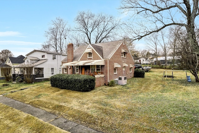 view of front of house with central AC unit and a front lawn