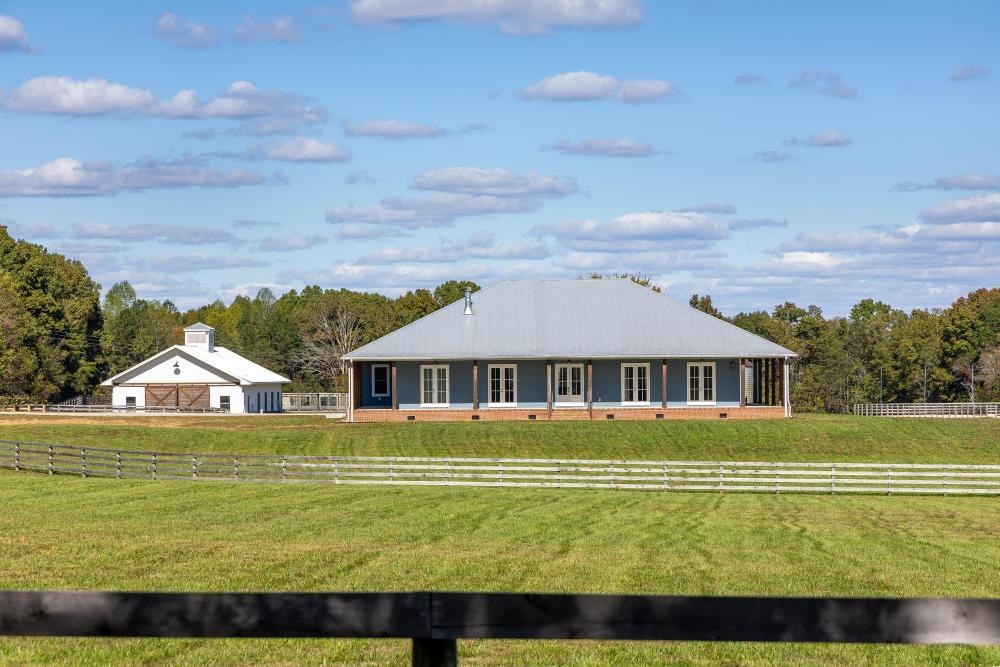 view of front of home featuring a rural view and a front lawn