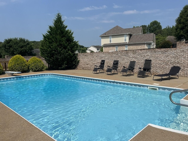 view of swimming pool with a diving board