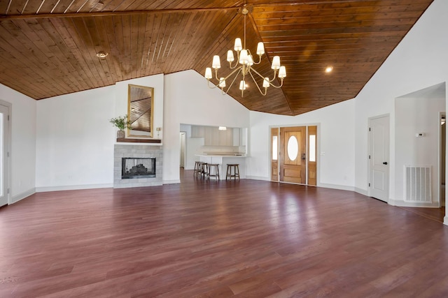 unfurnished living room with an inviting chandelier, wood ceiling, dark wood-type flooring, a multi sided fireplace, and a towering ceiling