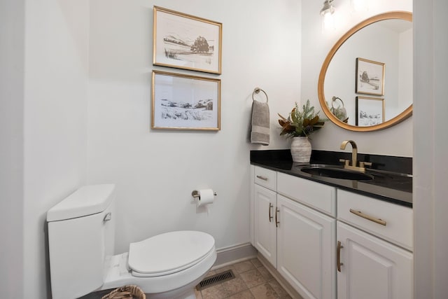 bathroom with toilet, vanity, and tile patterned flooring