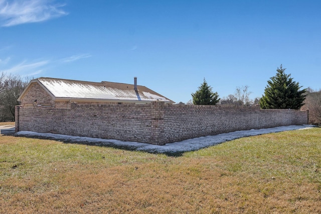 view of side of home with a yard