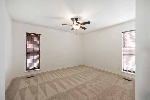 spare room featuring ceiling fan and light colored carpet