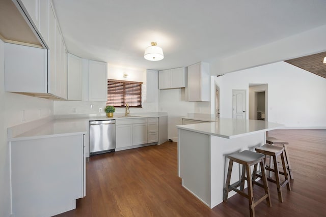 kitchen featuring a center island, dark hardwood / wood-style flooring, stainless steel dishwasher, white cabinets, and sink