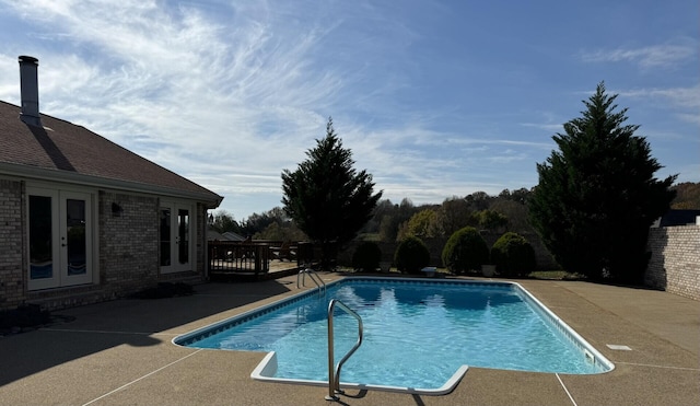 view of swimming pool featuring a patio area and french doors