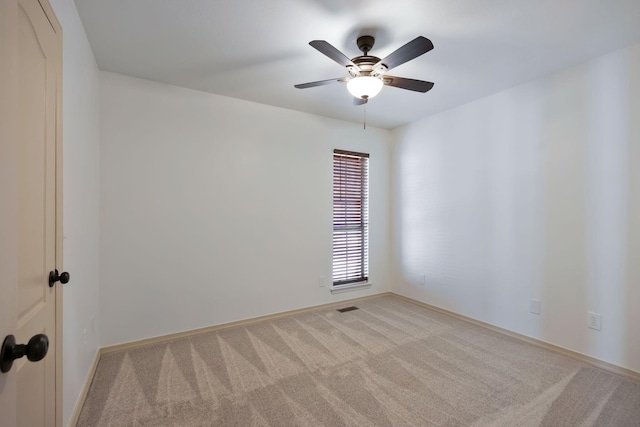 spare room featuring light carpet and ceiling fan