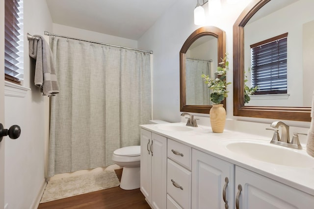 bathroom with curtained shower, hardwood / wood-style floors, toilet, and vanity