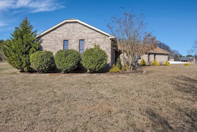 view of side of home with a yard