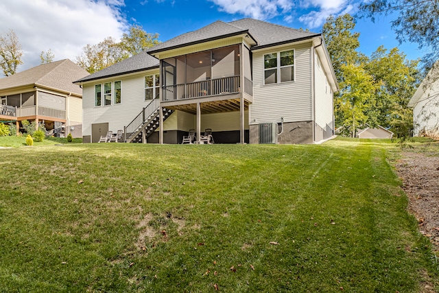 rear view of property featuring a sunroom, a yard, and central AC