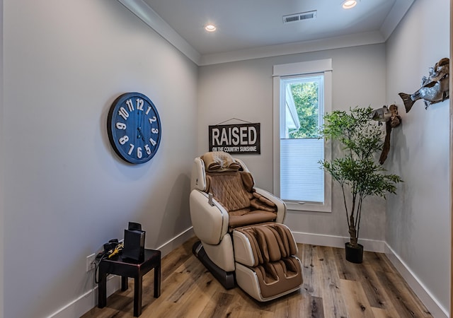 sitting room with hardwood / wood-style flooring and ornamental molding