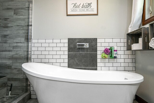 bathroom with tile walls and a bathing tub