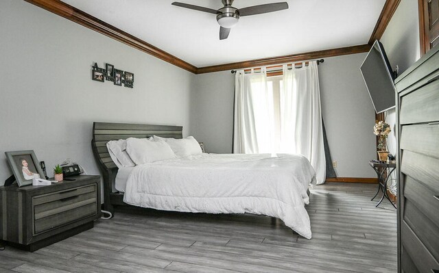 bedroom featuring hardwood / wood-style floors, ceiling fan, and crown molding