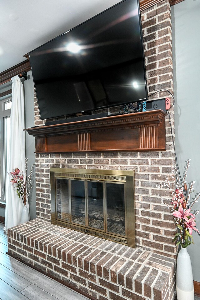 interior details featuring hardwood / wood-style floors and a brick fireplace