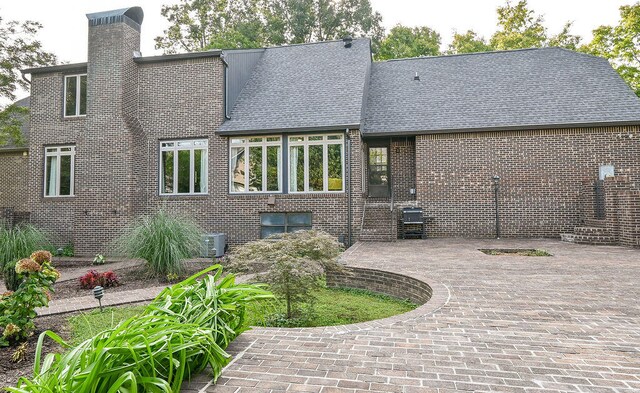 rear view of house featuring cooling unit and a patio