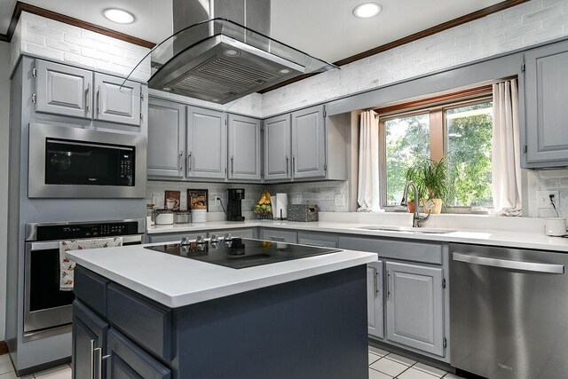 kitchen featuring a center island, crown molding, sink, appliances with stainless steel finishes, and island exhaust hood