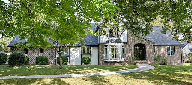 tudor-style house with a front yard