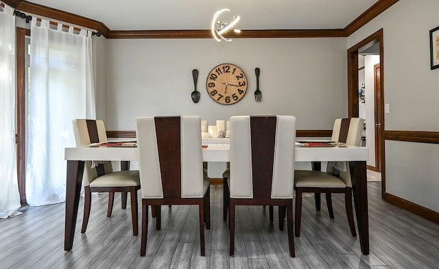 dining room with wood-type flooring and crown molding