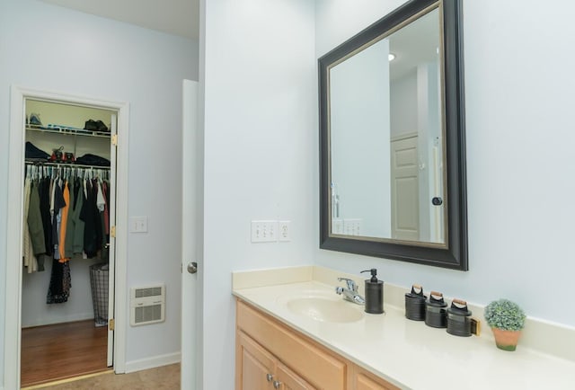 328 Mill Hamlet Rd NW, Charleston, TN 37310 - bathroom with vanity, heating unit, a walk in closet, and baseboards