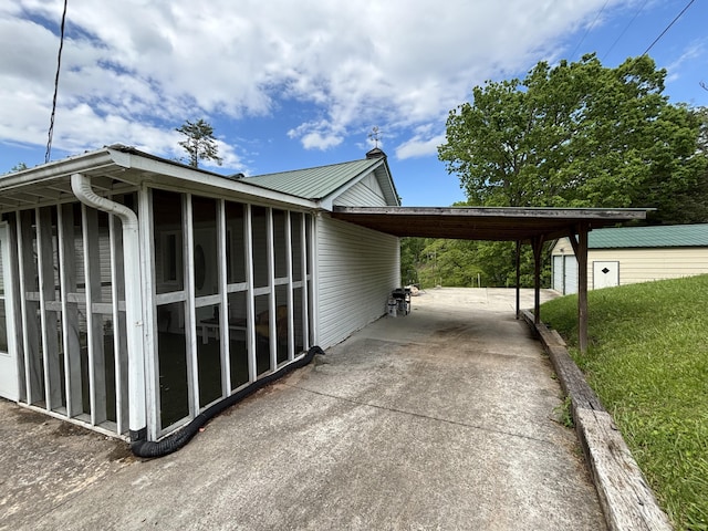 122 Meredith Dr, Turtletown, TN 37391 - view of home's exterior with concrete driveway, a sunroom, a carport, metal roof, and a lawn