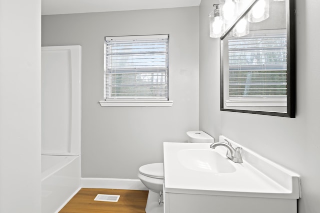 full bathroom with vanity, hardwood / wood-style flooring, toilet, and  shower combination