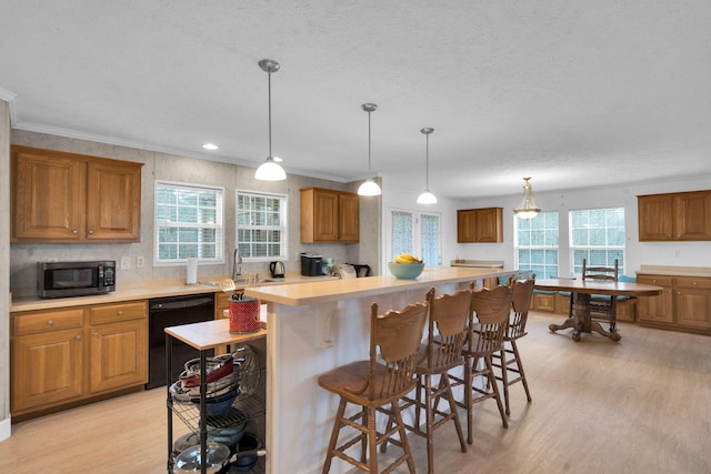 kitchen with brown cabinetry, a kitchen island, light wood-style flooring, light countertops, and dishwasher