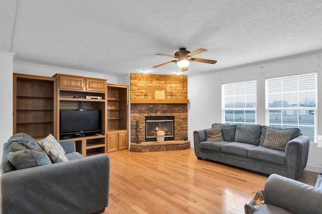 living room with a fireplace, a healthy amount of sunlight, and light wood-type flooring